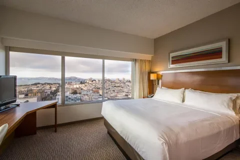 standard guest room showing king size bed, work desk and windows