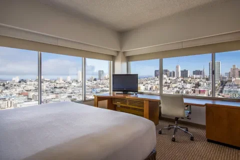 corner guest rooms showing king size bed work desk and windows on two sides