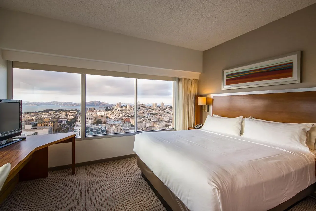 standard guest room showing king size bed, work desk and windows