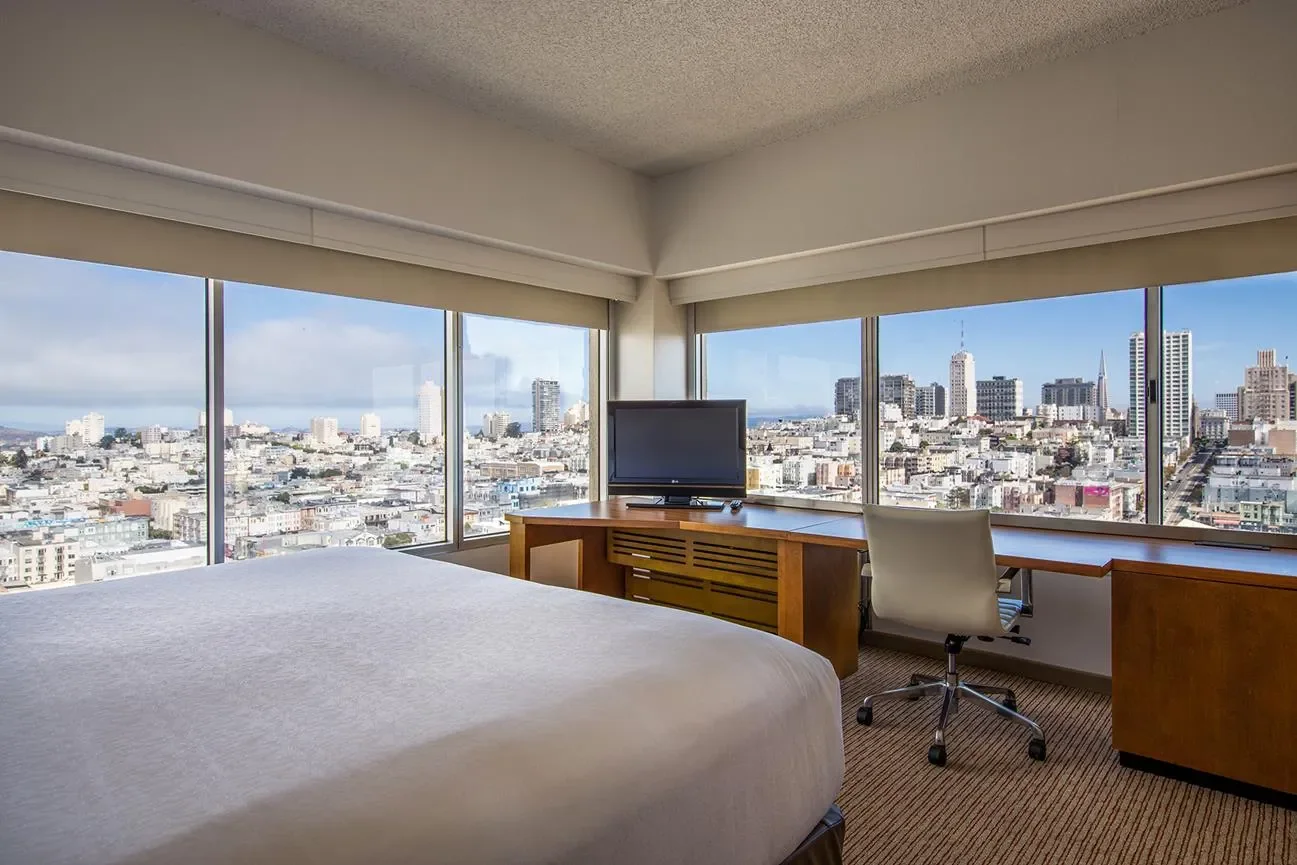 corner guest rooms showing king size bed work desk and windows on two sides